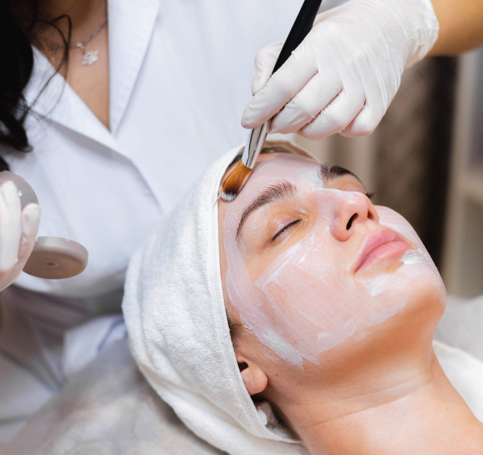 beautician with brush applies white moisturizing mask face young girl client spa beauty salon scaled e1753886899331