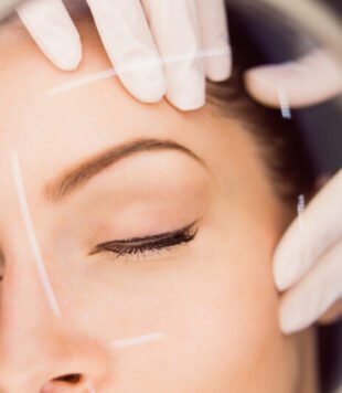 dermatologist examining female patient skin scaled e1753992103941